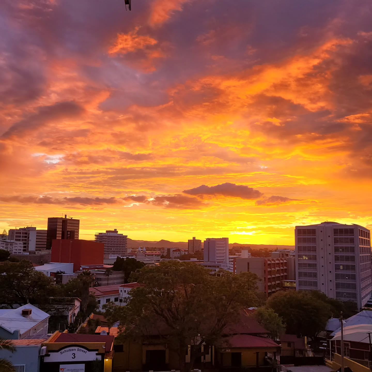 An intense orange and violet sunset above central Windhoek
